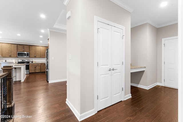 corridor with dark hardwood / wood-style floors and crown molding