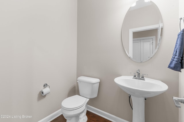 bathroom featuring wood-type flooring and toilet