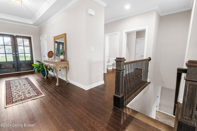 entrance foyer featuring dark hardwood / wood-style flooring, crown molding, and french doors