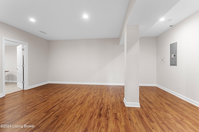 unfurnished room with electric panel and hardwood / wood-style floors