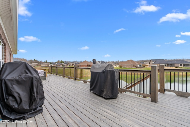 wooden deck with area for grilling and a water view