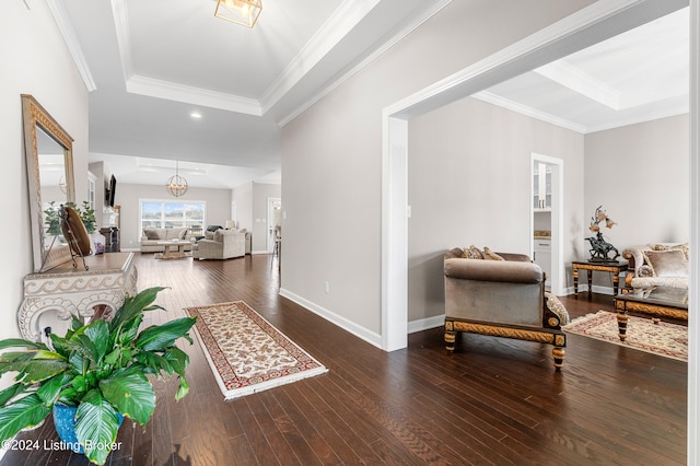 entrance foyer featuring hardwood / wood-style floors, crown molding, and a notable chandelier