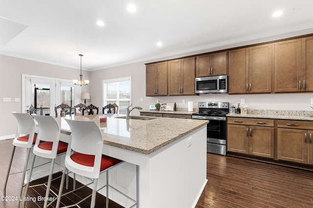 kitchen with a kitchen island with sink, sink, hanging light fixtures, dark hardwood / wood-style floors, and stainless steel appliances