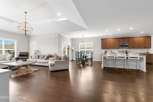 living room featuring dark hardwood / wood-style floors, ornamental molding, and a chandelier