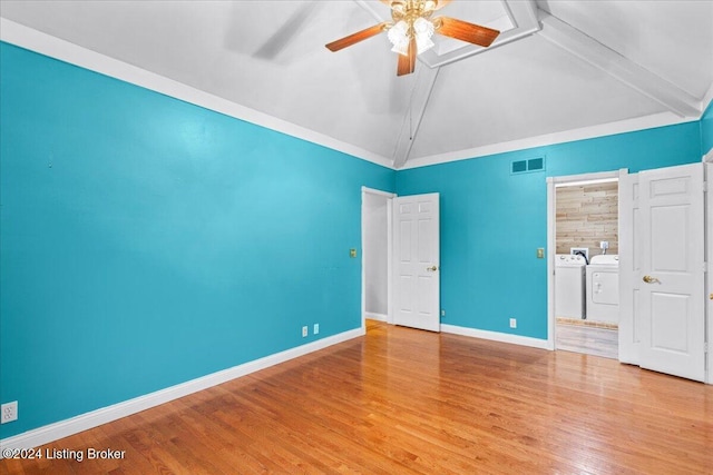 unfurnished bedroom featuring washing machine and dryer, visible vents, baseboards, vaulted ceiling, and light wood-type flooring