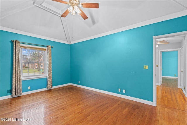 spare room with a ceiling fan, lofted ceiling, baseboards, and wood finished floors