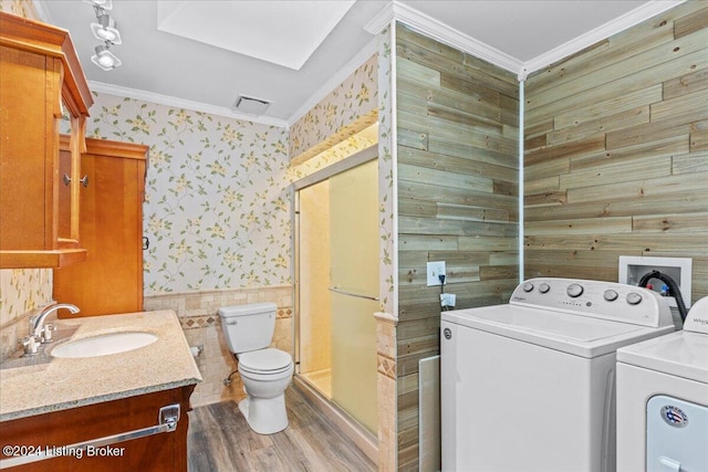 laundry area with laundry area, separate washer and dryer, a sink, wallpapered walls, and crown molding