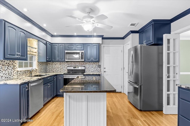 kitchen featuring blue cabinetry, stainless steel appliances, visible vents, ornamental molding, and a sink