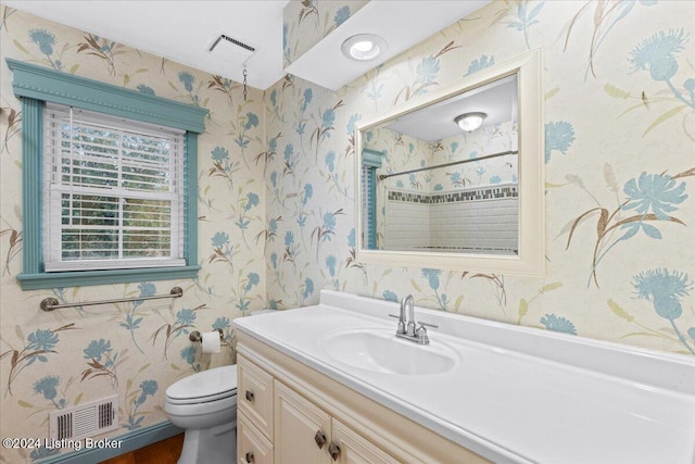 bathroom featuring toilet, vanity, visible vents, a shower, and wallpapered walls