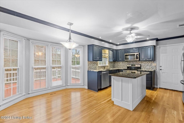 kitchen with crown molding, stainless steel appliances, decorative backsplash, light wood-style floors, and a sink