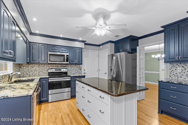 kitchen featuring crown molding, appliances with stainless steel finishes, a sink, blue cabinets, and light wood-type flooring