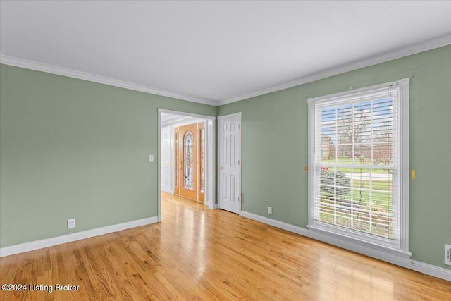 spare room featuring a wealth of natural light, baseboards, and wood finished floors