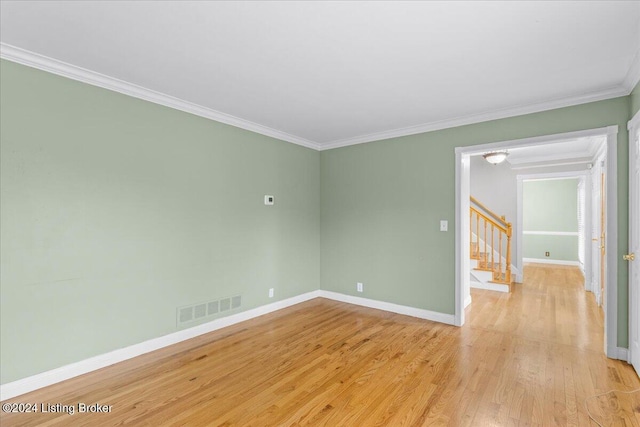 spare room with baseboards, visible vents, stairway, ornamental molding, and light wood-style floors