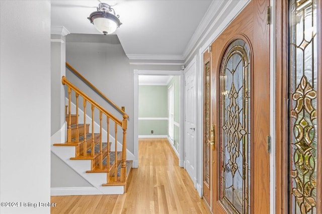 foyer entrance with baseboards, stairway, wood finished floors, and crown molding