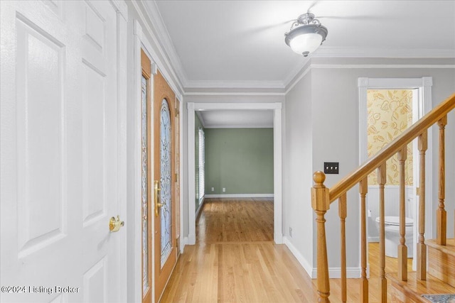 hallway featuring baseboards, stairway, light wood finished floors, plenty of natural light, and crown molding