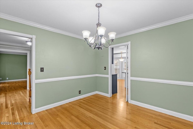 unfurnished dining area with a chandelier, crown molding, baseboards, and wood finished floors