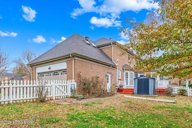 view of property exterior featuring brick siding, an attached garage, a storage shed, fence, and an outdoor structure