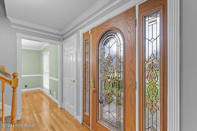 foyer entrance with visible vents, baseboards, light wood-style floors, stairway, and crown molding