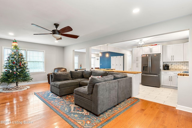 living room with light hardwood / wood-style flooring and ceiling fan