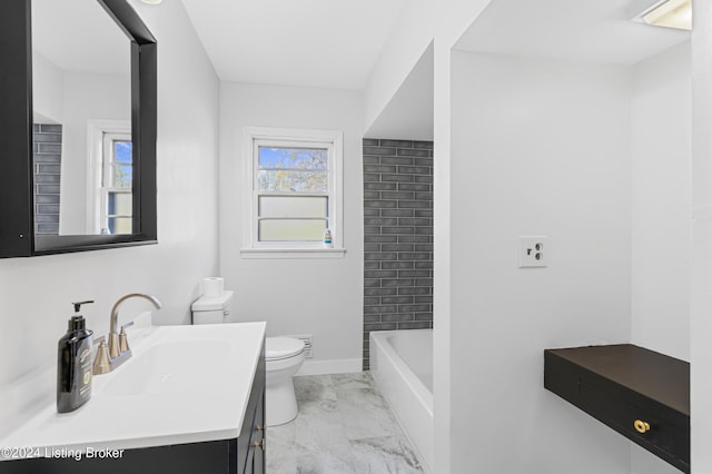 bathroom with a bathtub, plenty of natural light, vanity, and toilet