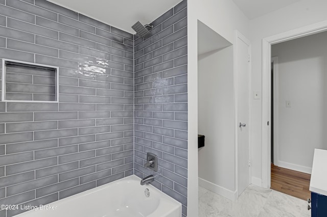 bathroom with hardwood / wood-style flooring and tiled shower / bath