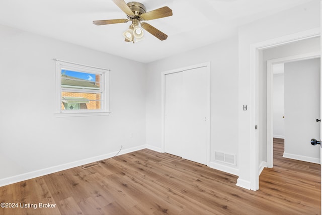 unfurnished bedroom featuring a closet, hardwood / wood-style flooring, and ceiling fan