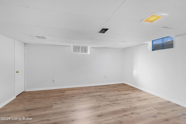 basement with a paneled ceiling and wood-type flooring