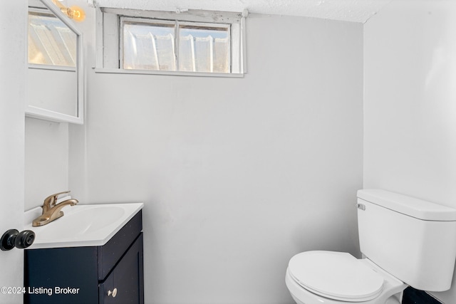 bathroom with vanity, toilet, and a textured ceiling