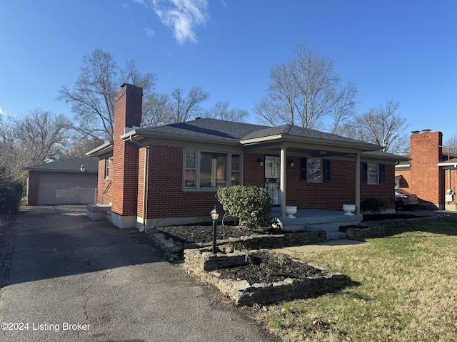 single story home with an outbuilding, a garage, and a front yard