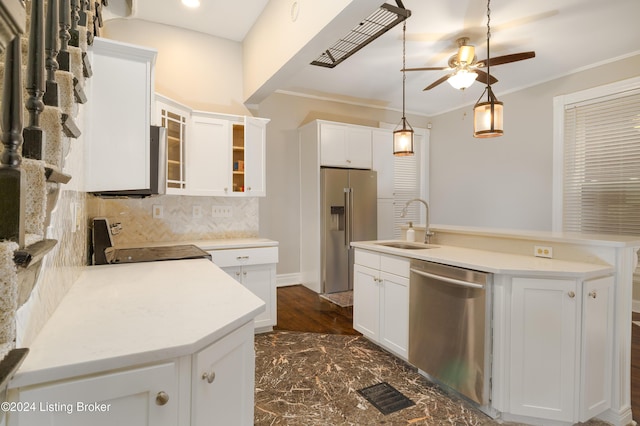 kitchen with sink, a kitchen island with sink, stainless steel appliances, decorative backsplash, and white cabinets