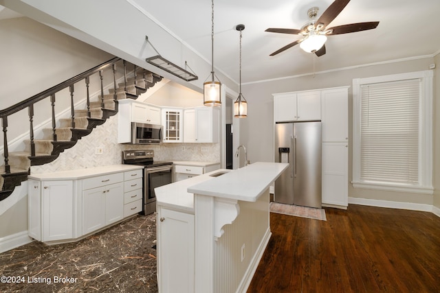 kitchen with white cabinetry, a kitchen island with sink, ornamental molding, and appliances with stainless steel finishes