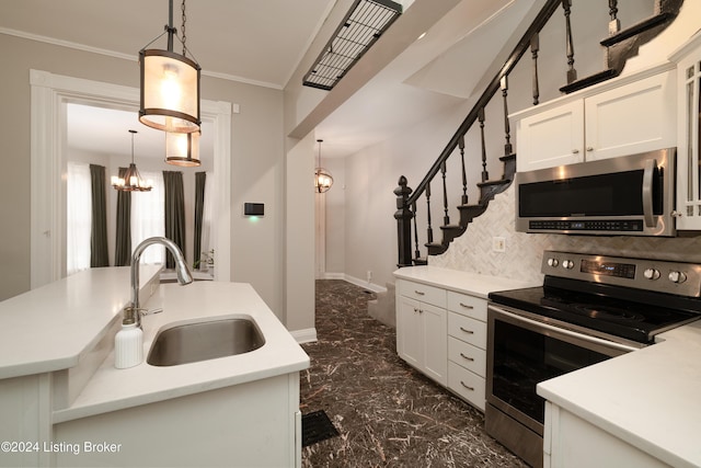 kitchen featuring hanging light fixtures, white cabinetry, sink, and stainless steel appliances