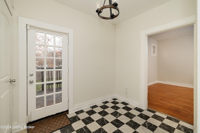 entryway with dark wood-type flooring and an inviting chandelier