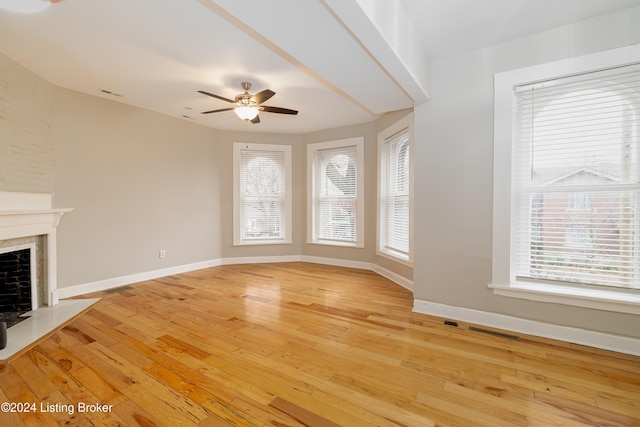 unfurnished living room featuring a wealth of natural light, light hardwood / wood-style flooring, and ceiling fan