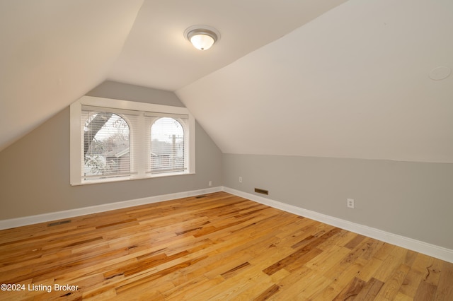 bonus room featuring vaulted ceiling and light hardwood / wood-style flooring