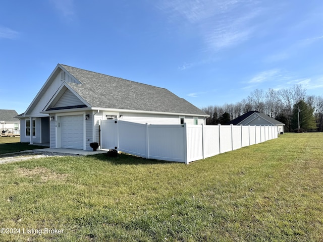 view of side of property featuring a yard and a garage