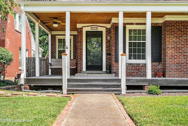 view of exterior entry with a porch, brick siding, and ceiling fan