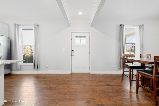 entrance foyer with ornamental molding, dark hardwood / wood-style flooring, and a wealth of natural light