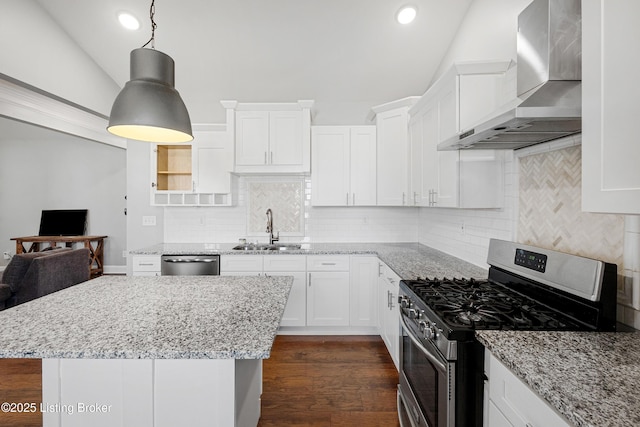 kitchen featuring pendant lighting, sink, appliances with stainless steel finishes, white cabinetry, and wall chimney exhaust hood