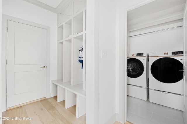 mudroom with washer and dryer, light wood-type flooring, and crown molding