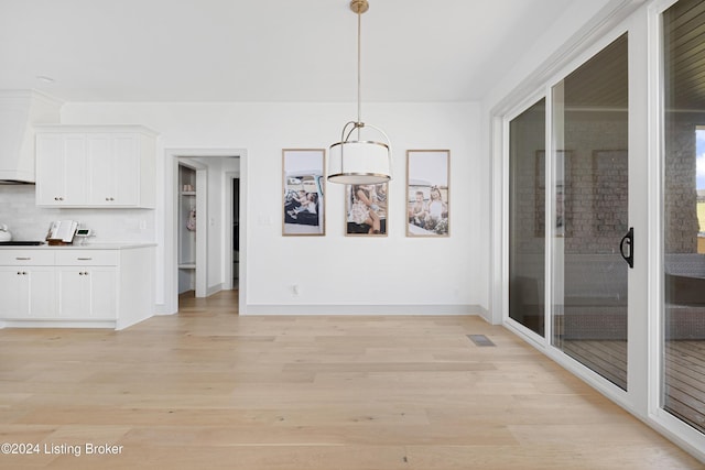 unfurnished dining area with light wood-type flooring