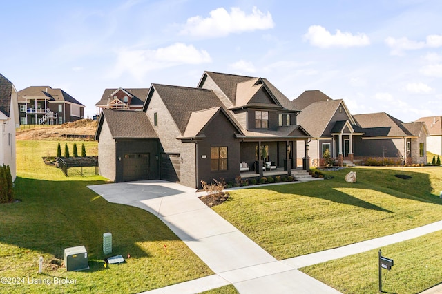 view of front of house featuring a front yard, a porch, and a garage