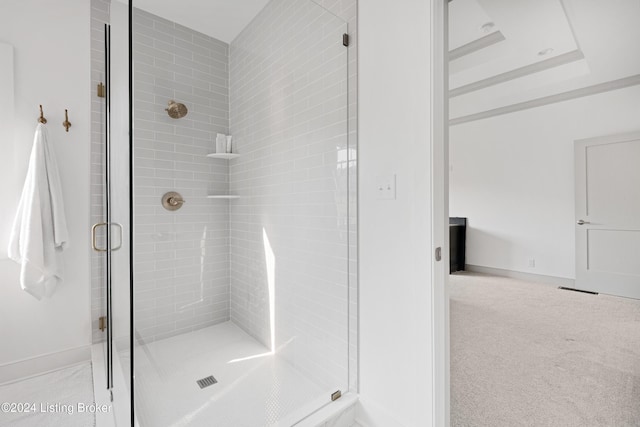 bathroom with a raised ceiling and walk in shower