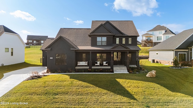 rear view of house featuring a lawn and covered porch