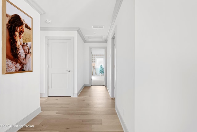 corridor featuring ornamental molding and light hardwood / wood-style flooring