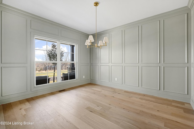 unfurnished dining area with light hardwood / wood-style flooring and an inviting chandelier