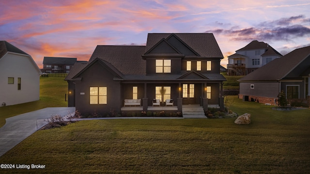 view of front facade with a lawn and covered porch