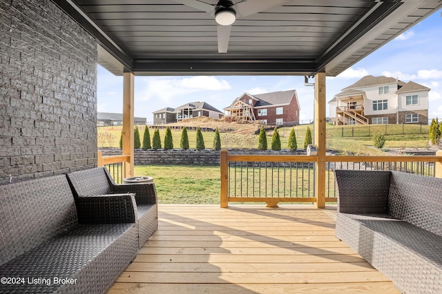 wooden deck featuring a lawn and ceiling fan