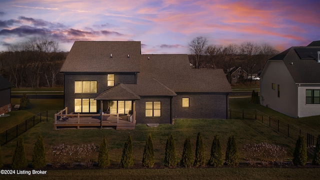 back house at dusk featuring a deck