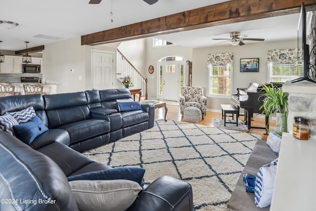 living room with beamed ceiling, hardwood / wood-style floors, and ceiling fan